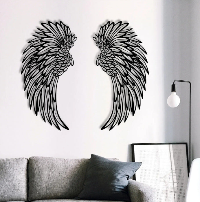 Black metal angel wings on a wall above a grey sofa