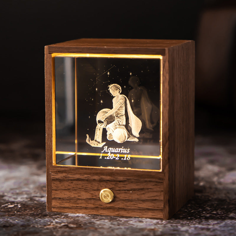 Lit Aquarius crystal night light with engraved figure and constellation in a walnut base