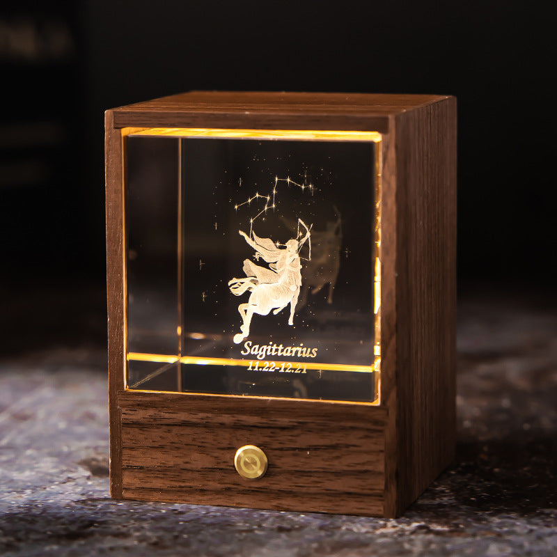 Lit Sagittarius crystal night light with engraved figure and constellation in a walnut base
