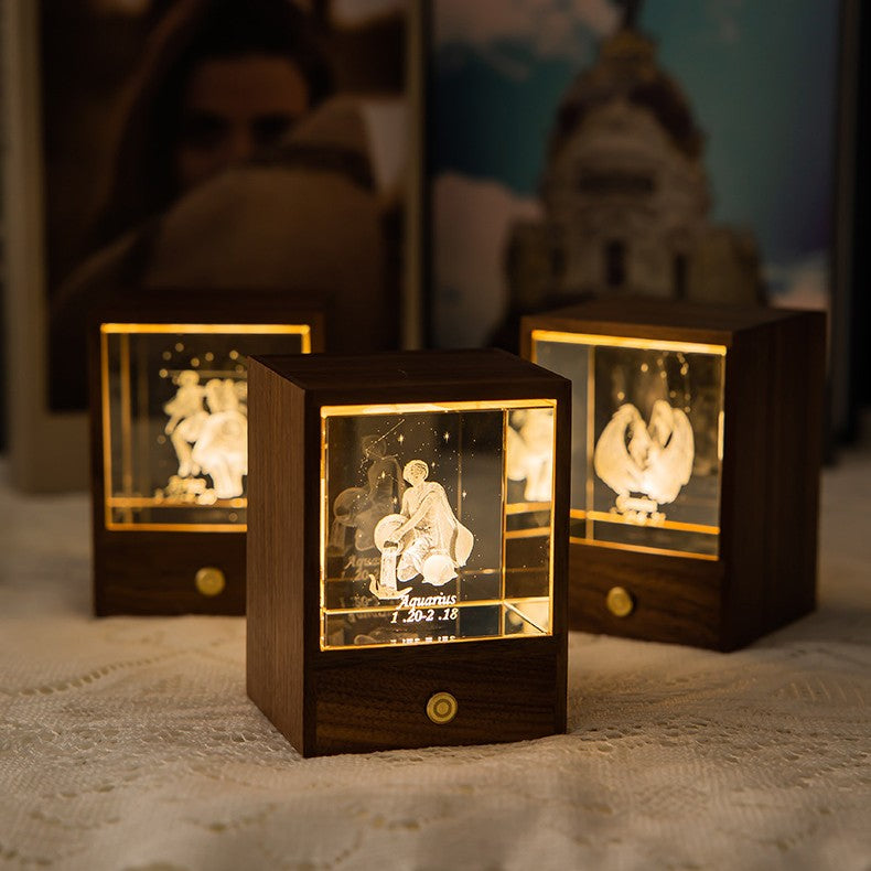 Three lit zodiac crystal night lights with walnut wood bases