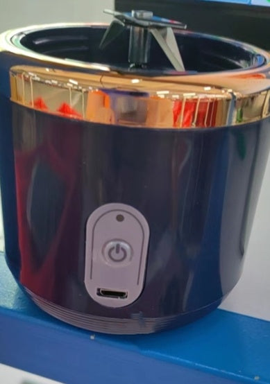 Close-up of the navy blender base with power button and charging port