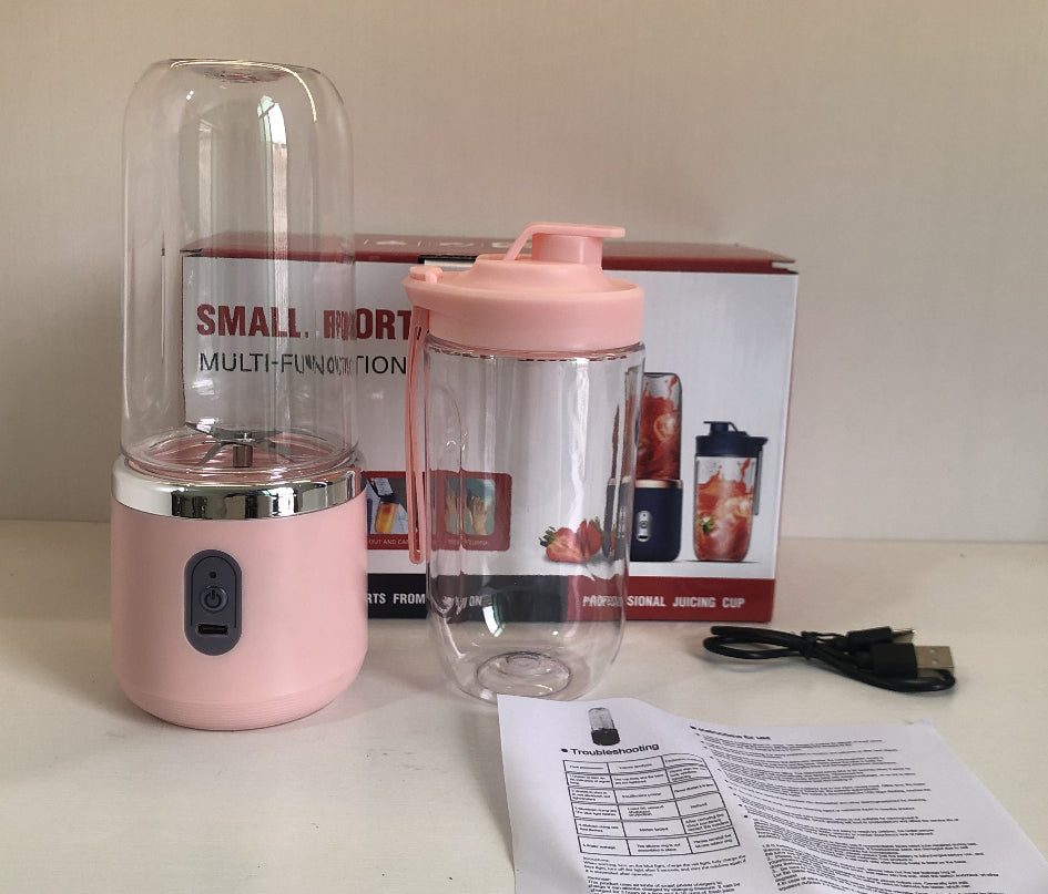 Pink portable blender with travel cup, box, USB cable and manual