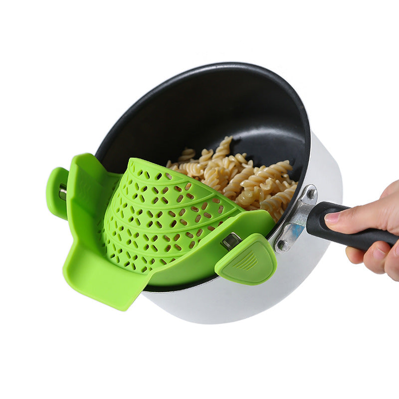 Green clip-on silicone strainer attached to a pot rim