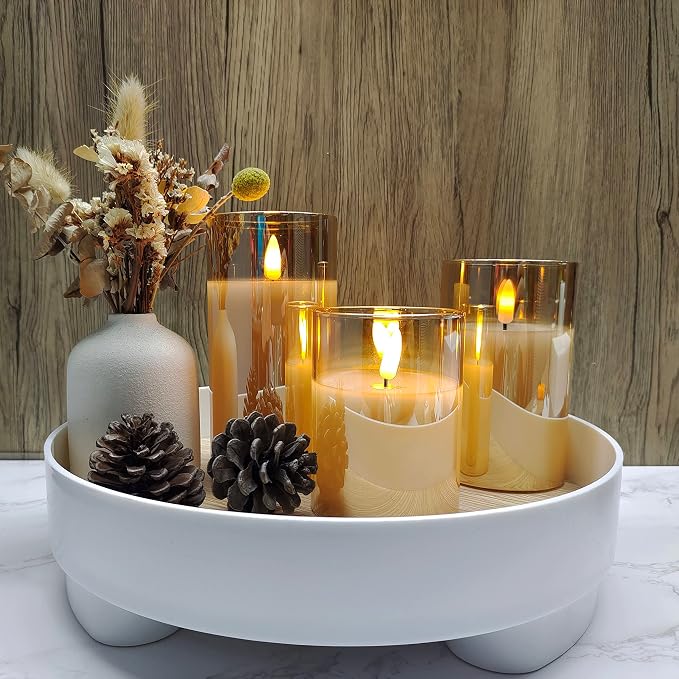 Gold glass flameless candles in a white tray with pinecones and dried flowers