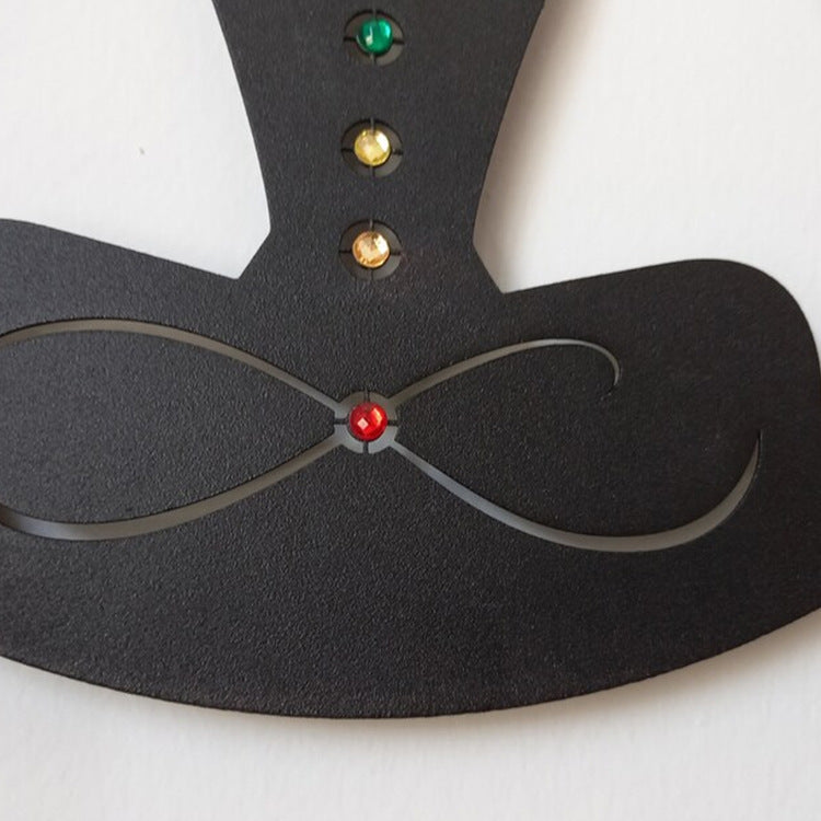 Close-up of the colored gem details and infinity symbol on the meditating figure