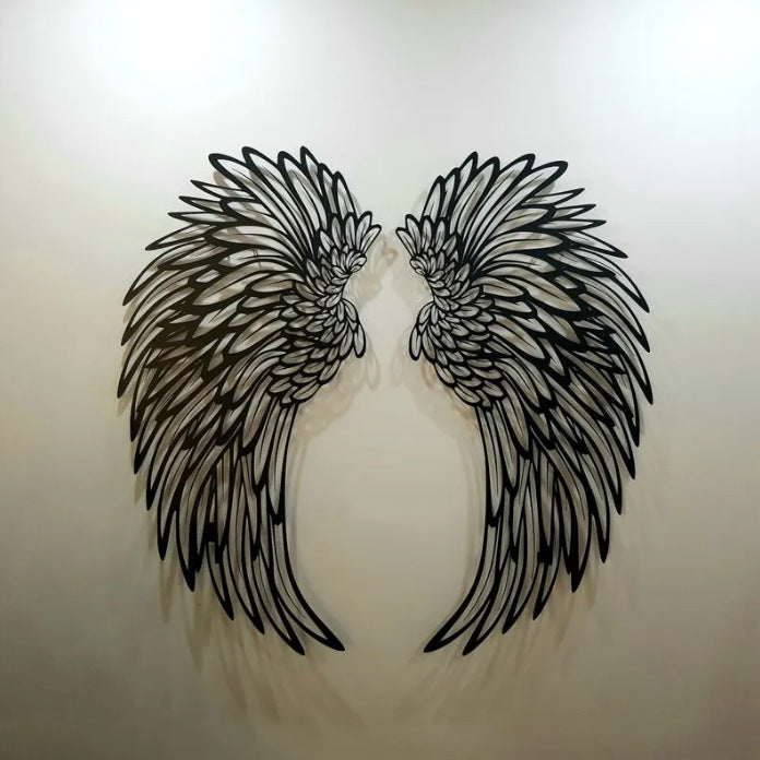 Large pair of black metal angel wings on a white wall